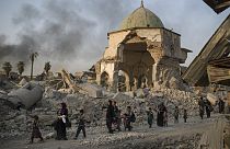  مدنيون عراقيون يفرون من مسجد النوري الذي تعرض لأضرار جسيمة في مدينة الموصل القديمة بالعراق