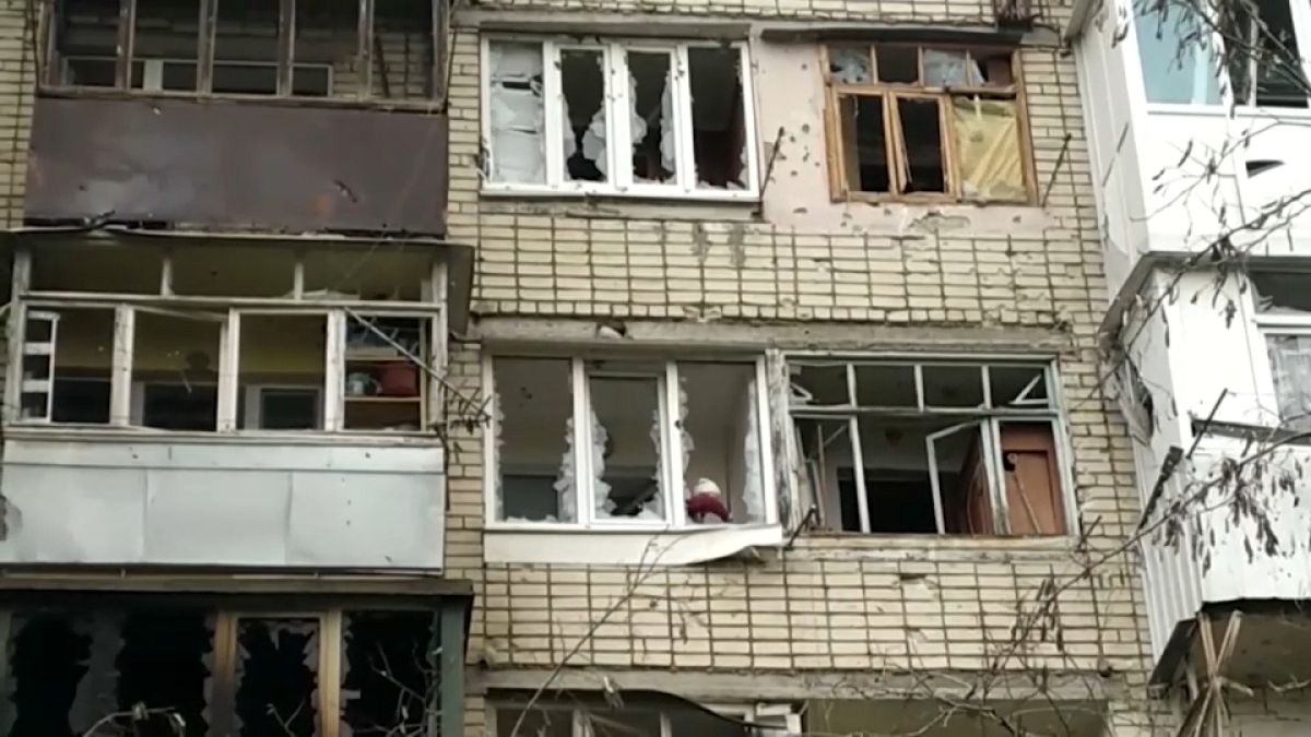 Un habitant à sa fenêtre détruite par un bombardement dans le quartier de Korabel, de la ville de Kherson, en Ukraine le 29 décembre 2022.