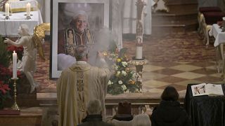 Creyentes y clérigos asisten a una misa por el papa emérito Benedicto XVI en la iglesia de Santa Magdalena en Altoetting, Alemania.