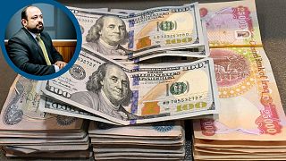 اسکناس‌های دلار آمریکا و دینار عراق در بازار ارز شهر ناصریه در جنوب عراق