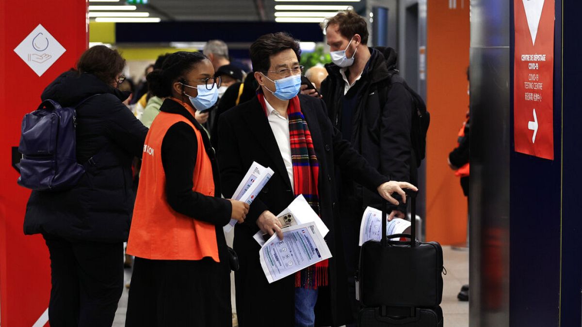 أشخاص قادمون من الصين ينتظرون أمام منطقة اختبار كوفيد-19 في مطار شارل ديغول، شمال باريس، 1 يناير 2023.