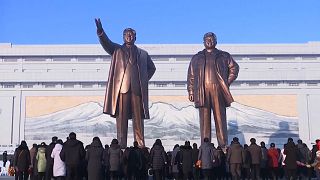 Crowds lay flowers and bow at giant statues of former leaders Kim Il Sung and Kim Jong Il in Pyongyang