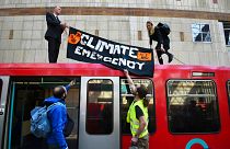 Climate activists atop a Dockland Light Railway carriage at Canary Wharf station in London, as part of the ongoing climate change protests in the capital, 17 April 2019 