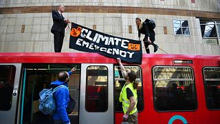 Climate activists atop a Dockland Light Railway carriage at Canary Wharf station in London, as part of the ongoing climate change protests in the capital, 17 April 2019 