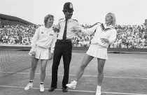 FILE - Chris Evert, left, and Martina Navratilova joke with police officer Les Bowie on Number Two Court at Wimbledon in London on July 4, 1985
