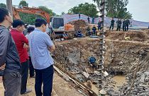 عمال الإنقاذ ينظرون إلى أسفل الموقع حيث يُعتقد أن صبيًا يبلغ من العمر 10 سنوات محاصر في عمود بعمق 35 مترًا في منطقة بناء جسر في مقاطعة دونغ ثاب الفيتنامية. 2023/01/02