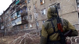 FILE: A pro-Russian fighter looks at a building on February 1, 2015 after it was damaged by shelling the day before in Makiivka
