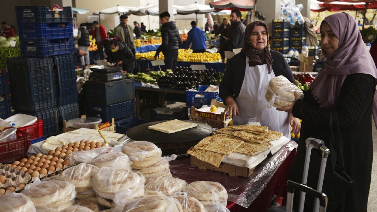 Hagyományos kenyeret vásárló nő egy ankarai piacon