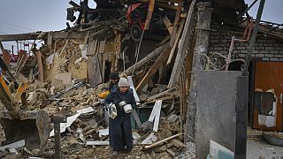 Anwohner:innen suchen nach Habseligkeiten in den Trümmern eines Hauses in Saporischschja, 1. Januar 2023.