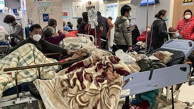 Пациенты получают лечение в переполненных коридорах больницы, Шанхай, 3 января 2023 года.