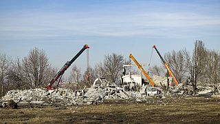 Trabalhadores limpam escombros após mísseis ucranianos terem atingido Makiivka, na região de Donetsk, controlada pela Rússia, no leste da Ucrânia