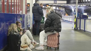 ركاب ينتظرون مغادرة القطار في محطة يوستون للسكك الحديدية بينما ينظم أعضاء عمال السكك الحديدية إضرابًا في لندن. 2022/12/13
