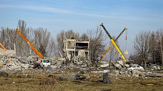 Workers clean rubbles after Ukrainian rocket strike in Makiivka, in Russian-controlled Donetsk region, eastern Ukraine, Tuesday, Jan. 3, 2023.