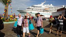 سياح أوروبيون ينزلون من سفينة أماديا البحرية في ميناء الغواماش بجزيرة مارغاريتا في فنزويلا.