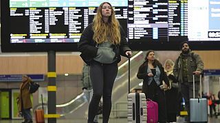 Una joven espera su tren en Londres, Reino Unido