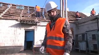 Un bénévole ukrainien en train de reconstruire une maison à Stepne