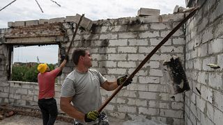 Voluntários trabalham no restauro de uma habitação perto de Chernihiv, na Ucrânia