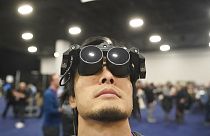 Un homme fait la démonstration du casque de réalité virtuelle Megane X, plus léger et compact que ses concurrents.