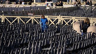 Workers clean seating put in place for the funeral, in St. Peter's Square at the Vatican, Wednesday, Jan. 4, 2023.