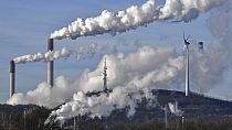 Almanya'nın Gelsenkirchen kentinde bir rüzgar jeneratörünün yanında Uniper enerji şirketine ait kömürlü termik santrali ve BP rafinerisi
