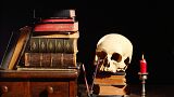 A skull beside a pile of books