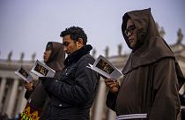 Des personnes prient pendant la messe des funérailles du Pape émérite Benoît XVI présidée par le Pape François sur la place Saint-Pierre au Vatican - 05.01.2023
