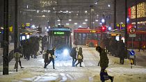 Straßenbahnen und Busse im Schneetreiben am Jernbanetorget im Zentrum von Oslo