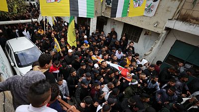 Mourners carry the flag-draped body of Palestinian teenager Amer Abu Zeitoun.