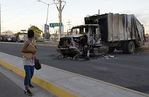 Une femme passe devant un camion incendié à Culiacan (Mexique).