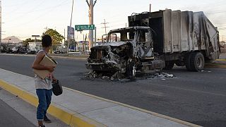 Une femme passe devant un camion incendié à Culiacan (Mexique).