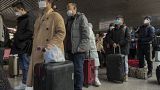 Viajeros chinos hacen cola en un aeropuerto