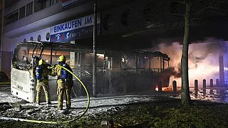 Берлинские пожарные тушат автобус обстрелянный во время погромов в новогоднюю ночь
