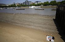 A man sun bathes on the beach on the bank of the River Thames in London, Friday, June 17, 2022.