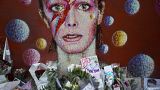 Tributes lie beneath a mural of singer David Bowie by artist Jimmy C in Brixton, south London. 