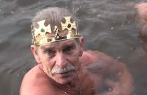 Man swims in freezing water for Epiphany. 