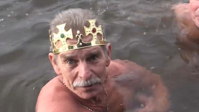 Man swims in freezing water for Epiphany. 