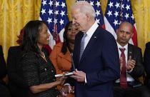 El presidente Joe Biden concediendo una medalla a una ciudadana estadounidense por su labor durante el asalto al Capitolio, en enero de 2021.