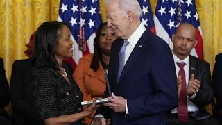 El presidente Joe Biden concediendo una medalla a una ciudadana estadounidense por su labor durante el asalto al Capitolio, en enero de 2021.