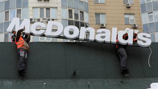 عمال يرفعون لافتة ماكدونالدز من مطعم في ألماتي في كازاخستان 06/01/2023