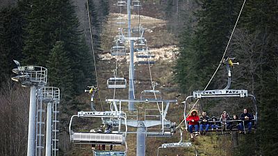 People ride the chair lift above the ski track without any snow on Bjelasnica mountain near Sarajevo, Bosnia in this file photo