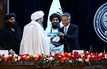 El embajador chino en Afganistán, Wang Yu, y el viceprimer ministro económico del gobierno provisional afgano, Mullah Abdul Ghani Baradar, firman el acuerdo en Kabul