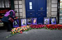 باقات من الزهور وُضعت أمام صور الناشطات الأكراد الراحلات ليلى سيليماز وسكينة جانسيز (الثانية إلى اليسار) وفيدان دوغان في باريس. 2023/01/04