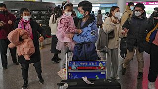 A man wearing a face mask meets with his child as he arrives from Hong Kong at Terminal 3 international arrival hall of the Beijing Capital International Airport in Beijing