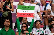 Iranian soccer fans hold up signs reading Woman Life Freedom, prior to the World Cup Iran v England, November 2022, Qatar