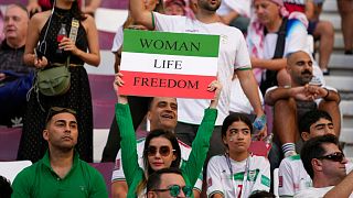 Iranian soccer fans hold up signs reading Woman Life Freedom, prior to the World Cup Iran v England, November 2022, Qatar Iranian soccer fans hold up signs reading Woman Life Freedom, prior to the World Cup Iran v England, November 2022, Qatar