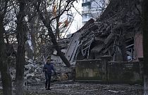 Ukrayna'nın Donetsk bölgesindeki Kramatorsk kentinde Rus saldırısı sırasında ağır hasar gören bir okul binasının önünden geçen vatandaş