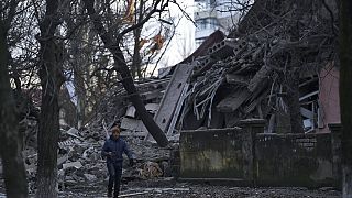 Ukrayna'nın Donetsk bölgesindeki Kramatorsk kentinde Rus saldırısı sırasında ağır hasar gören bir okul binasının önünden geçen vatandaş