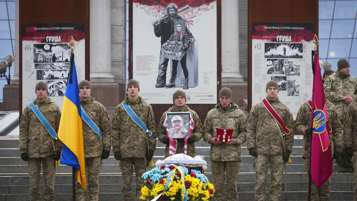 Ukrainian servicemen pay their last respect at the coffin of their comrade Oleh Yurchenko killed in a battlefield with Russian forces in the Donetsk, during a ceremony, 8 Jan.