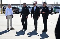   جو بايدن ووزير الأمن الداخلي أليخاندرو مايوركاس (يسار) يتحدثان مع شرطة الجمارك وحماية الحدود الأمريكية على جسر الأمريكتين الحدودي بين المكسيك والولايات المتحدة،8 يناير 2023