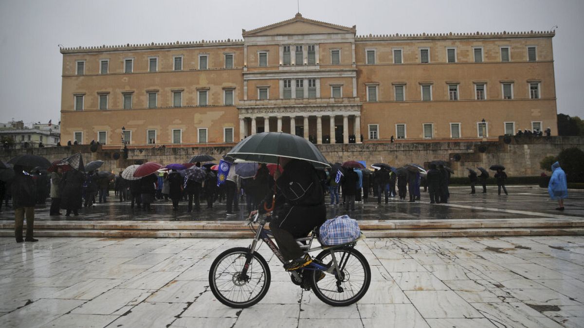 Ποδηλάτης με ομπρέλα στο κέντρο της Αθήνας